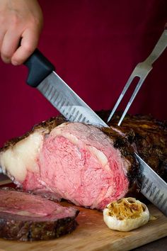 a person holding a knife cutting into a piece of meat