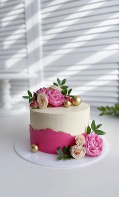 a white and pink cake with flowers on top