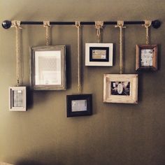 there are many frames hanging on the wall with rope attached to each one and two different pictures hung above them