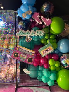 there is a display with balloons, boombox and other items on the shelf in front of it