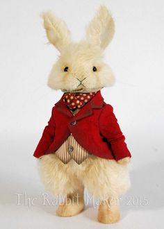 a stuffed rabbit wearing a red jacket and tie