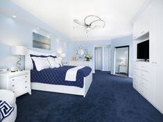 a bedroom with blue carpet and white furniture