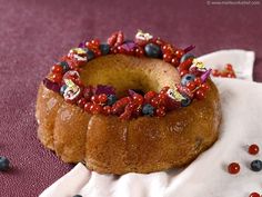 a bundt cake with berries and other toppings on it sitting on a napkin