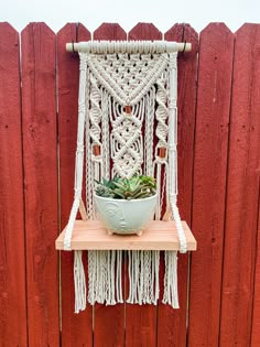 a macrame wall hanging with a bowl and succulent plant on it