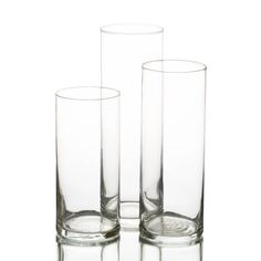 three clear glass vases sitting next to each other