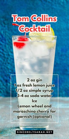 a tall glass filled with lemonade and ice on top of a table next to a blue wall