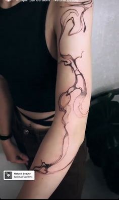 a woman with a tattoo on her arm is looking down at the camera and has an interesting design