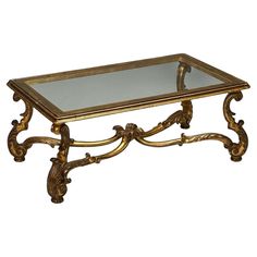 a gold coffee table with glass top