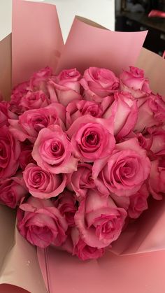 a bouquet of pink roses in a paper box