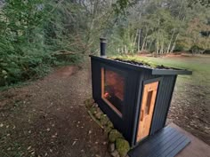 an outhouse in the woods with moss growing on top