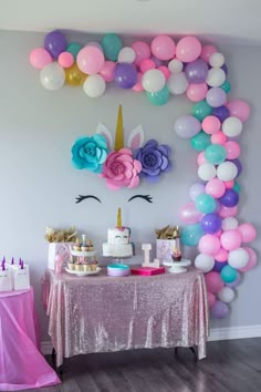 a unicorn themed birthday party with balloons and cake