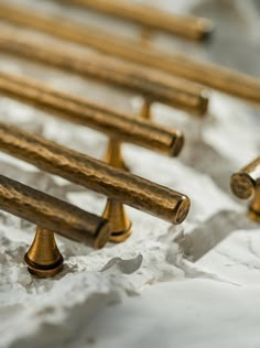 several brass colored benches sitting on top of a white sheet