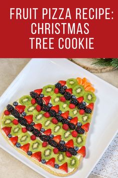 a white plate topped with fruit pizza and christmas tree cookie