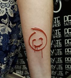 a person with a tattoo on their arm that has the letter c painted on it