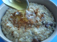 oatmeal with raisins and honey being poured into it