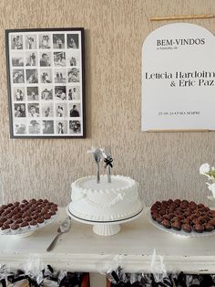 a table topped with cakes and cupcakes next to a poster on the wall