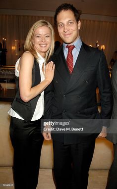 a man and woman standing next to each other in front of a couch at an event