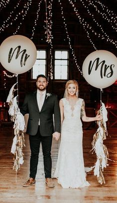 a bride and groom holding balloons that say mr and mrs