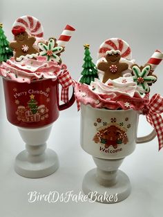 two coffee mugs decorated with christmas decorations