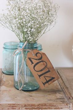 a mason jar filled with baby's breath sitting on top of a wooden table