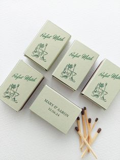 four matches are sitting next to each other on a white surface with green writing and illustrations