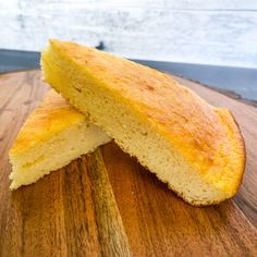 two pieces of bread sitting on top of a wooden cutting board next to each other