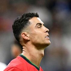 a soccer player looking up at the sky with his head turned to the side and eyes closed