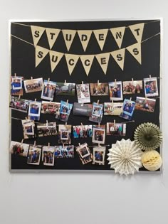 a bulletin board with pictures hanging on the wall and decorations around it that include flowers