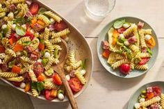 two plates with pasta salad and a wooden spoon