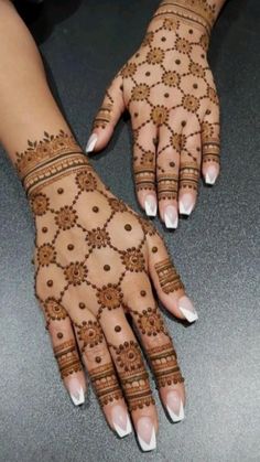 two hands with henna designs on them, one is white and the other is brown