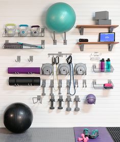 there is a gym room with exercise equipment on the wall and an exercise ball next to it