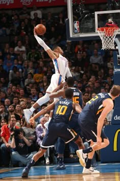 a group of men playing basketball against each other