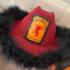 there is a red hat with black fur around it and a yellow label on the front