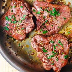 some meat is cooking in a pan on the table