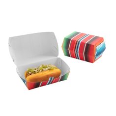 a hot dog with relish and onions in a paper container on a white background