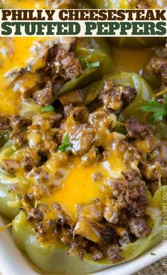 stuffed bell peppers in a white casserole dish with cheese and meat on top