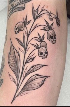 a tattoo with skulls and leaves on it