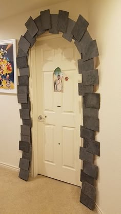 an arch made out of rocks is in the corner of a room with a door