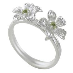 Two winter blooms with green hearts burst open at the top of this cocktail ring from Thailand featuring an elegantly simple design. Sarote Lochotinunt presents this ring which is crafted from sterling silver and fitted with petite stones of peridot. Formal Green Flower-shaped Ring, Green Flower Rings For May Birthstone, Green Flower-shaped Ring For May Birthstone, Elegant Green Flower Ring In Sterling Silver, Green Flower-shaped May Birthstone Ring, Elegant Green Sterling Silver Flower Ring, Green Sterling Silver Flower Wedding Ring, Green Open Flower Ring For Promise, Spring Green Ring As A Gift