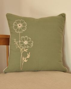 a green pillow sitting on top of a wooden chair