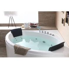 a large white bath tub sitting on top of a wooden floor