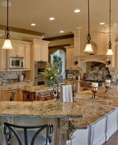 a large kitchen with marble counter tops and white cabinets