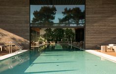 an empty swimming pool in front of a large building with glass doors on the side