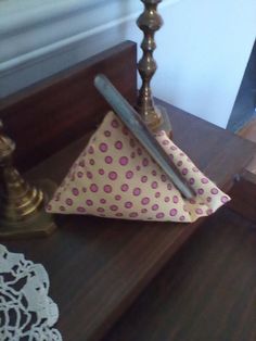 a small polka dot napkin on top of a wooden table next to a candle holder