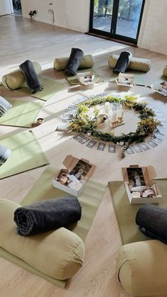 a group of people sitting on yoga mats in the middle of a room with pictures and candles