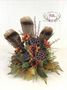 a vase filled with lots of different types of flowers and plants on top of a table