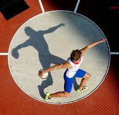 a man is throwing a ball on a tennis court with his arms outstretched in the air