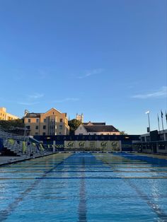 an empty swimming pool in front of some buildings