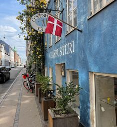 a blue building with a flag hanging from it's side next to a bike