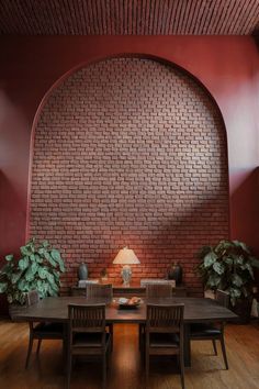 A dining room with a textured brick accent wall framed by a large arched feature. Textured Accent Wall, Stylish Inspiration